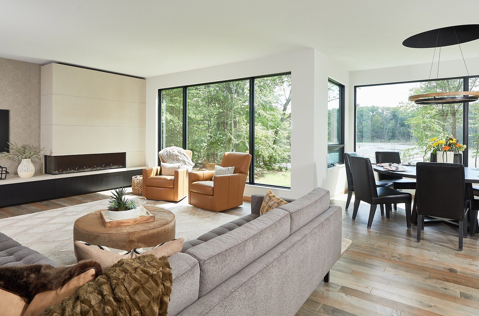 View of modern open plan living and dining area overlooking a lake