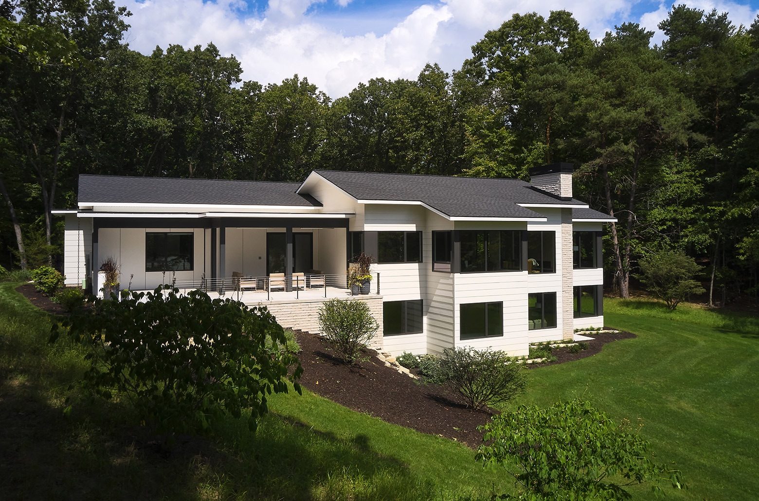 Rear view of a white modern home set into a hill